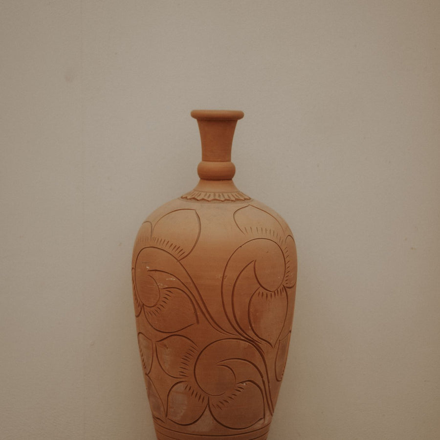 A terracotta vase carved in detail across the surface.