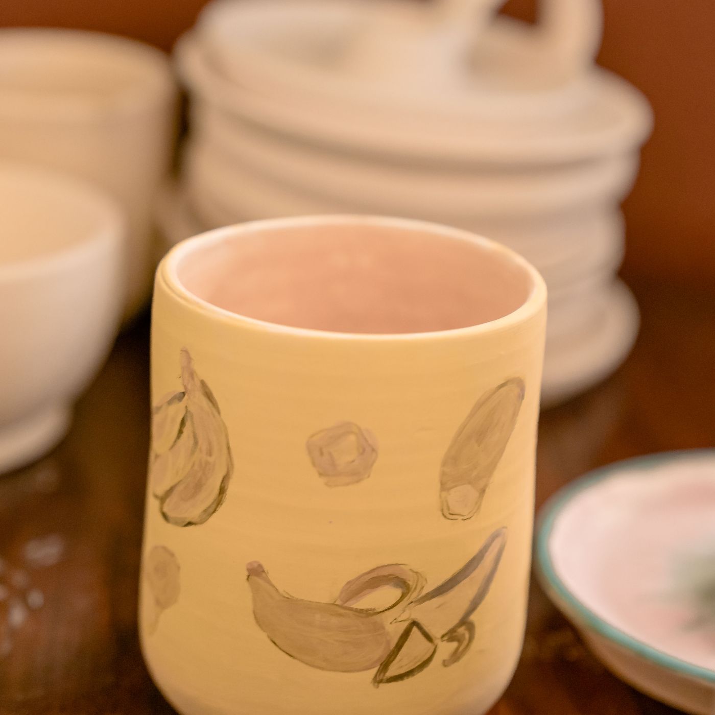 An artisan ceramic mug printed with banana graphics across the outer wall.