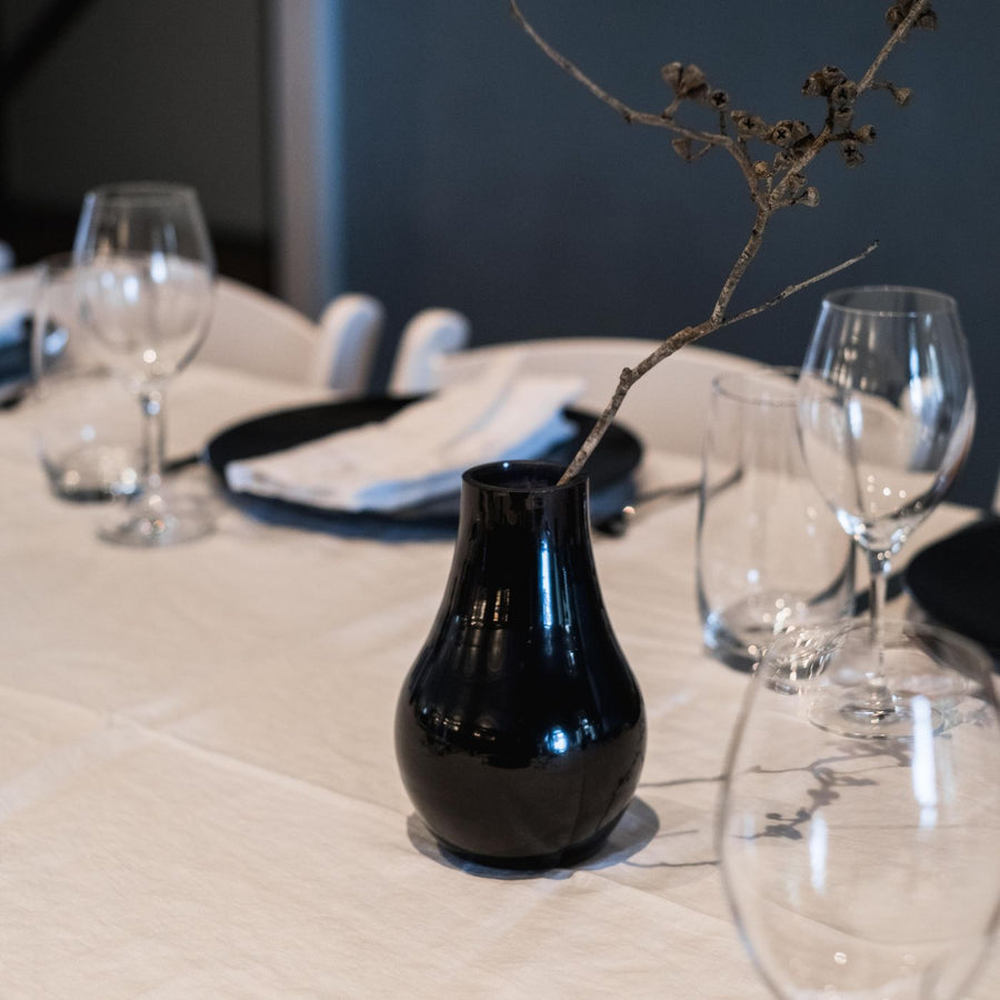 A black ceramic vase standing on a table.